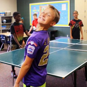 Summit student plays ping pong with friends during SAS. 