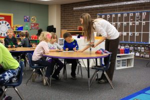 A Wallace elementary kindergarten teacher gives instructions to three kindergarten students. 