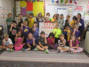 Third grade students in Melanie Sesker's class pose with a "Team Cooper" poster. 