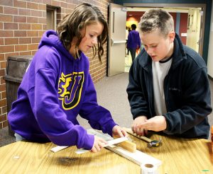 Summit seventh graders Rachael (left) and Conner (right) work together to build a simple machine representing interaction between literary characters. 