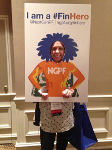 Kayla Bousum stands behind a cutout of a financial hero at a conference