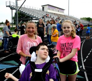 A Dragon Games participant is assisted by two peer helpers.