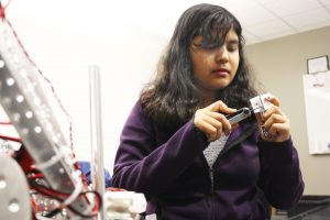 Seventh grader Sejal Sharma works on a piece of her team's competition robot during practice. 