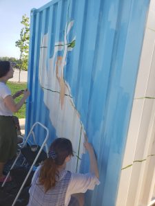 JHS art students paint a shipping container that will be used at the new Outdoor Learning Environmen
