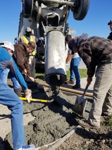 Students in Rhy South's Construction Technology class spread concrete for the OLE sidewalk area. 